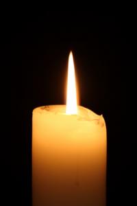 una vela encendida por un candelabro de flor de loto de cristal