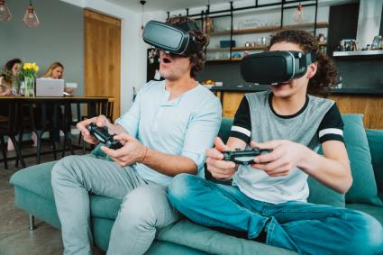 Padre y adolescente jugando juegos de realidad virtual