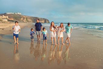 Gran familia mezclada caminando en la playa