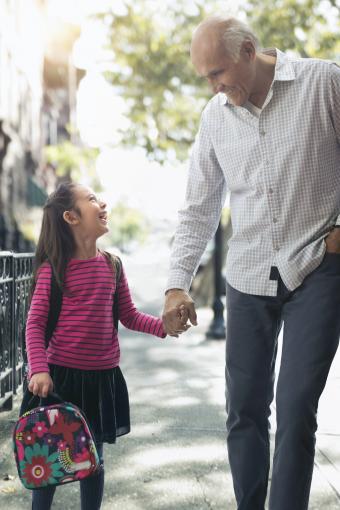 Abuelo caminando con su nieta a la escuela
